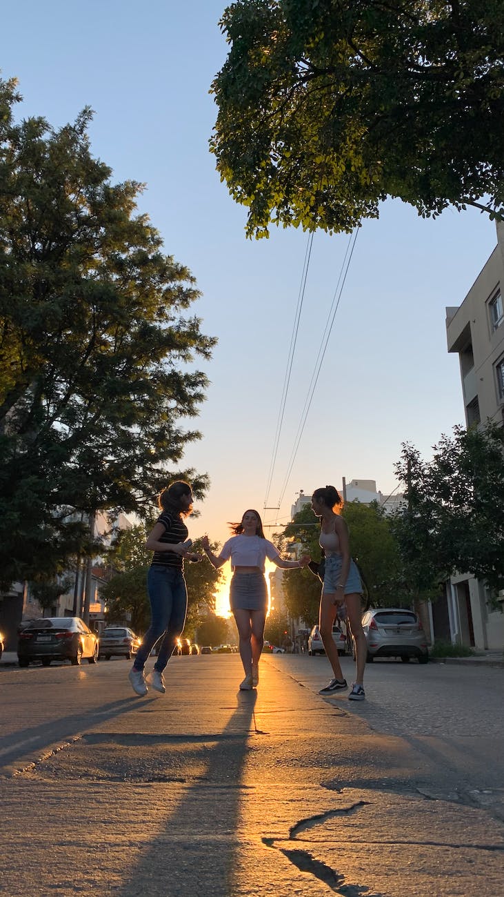 three women dancing on the road
